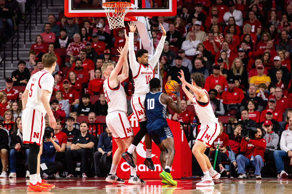 Nebraska guard Jamarques Lawrence (10) and forwards Rienk Mast (51) and Pryce Sandfort (21) defend against New Hampshire guard Comeh Emuobor (10) during the first half of an NCAA college basketball game, Tuesday, Dec. 30, 2025, in Lincoln, Neb. (AP Photo/Bonnie Ryan)