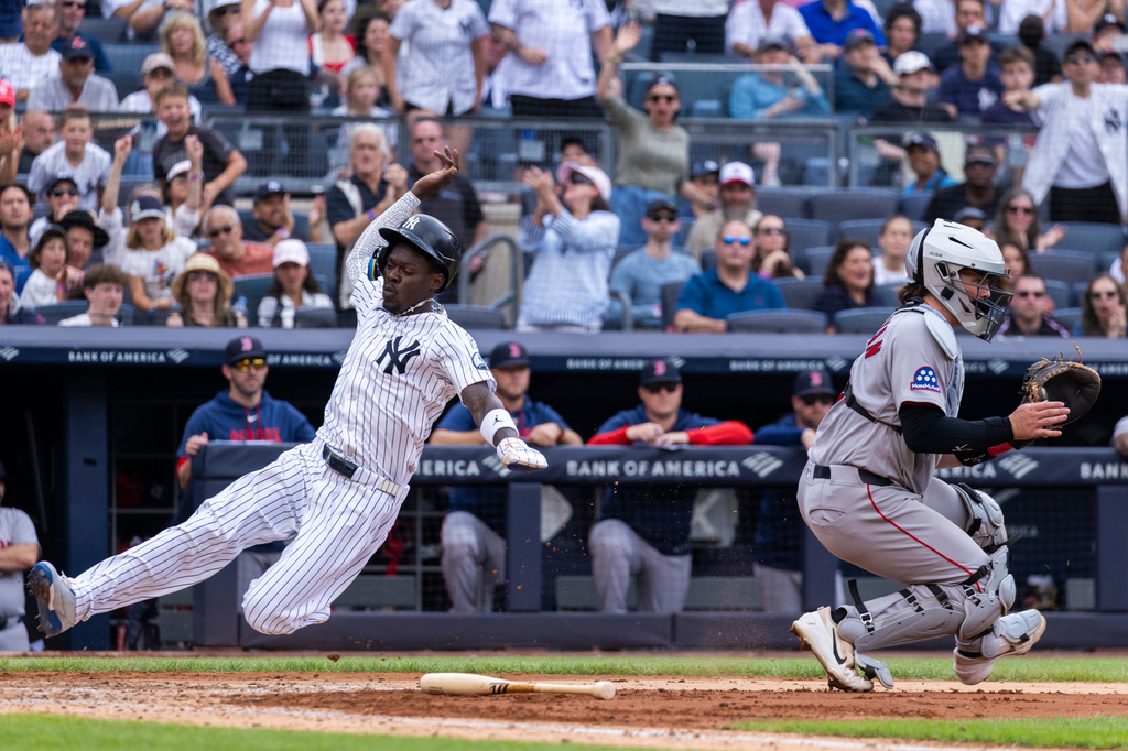 New York Yankees' Jazz Chisholm Jr. scores past Boston Red Sox catcher Adley Rutschman, right, after Yankees' Paul Goldschmidt hit a two-RBI single in the fifth inning during a baseball game, Sunday, Aug. 30, 2026, in New York. (AP Photo/Corey Sipkin)