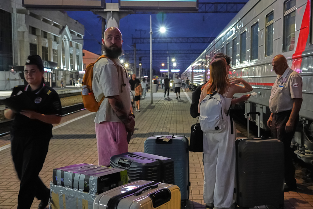 A 28-year-old digital content marketer who decided to leave Russia stands near his packed belongings at the railway station in Krasnodar, Russia, on Saturday, Aug. 29, 2026. He asked not to be identified because of security concerns. (AP Photo)