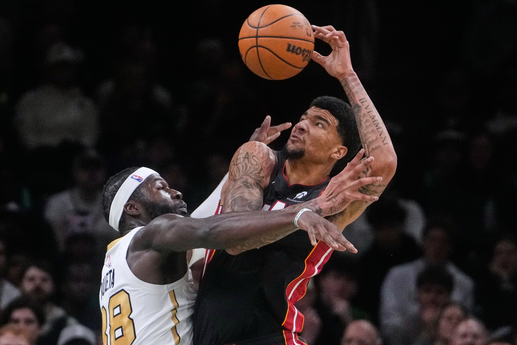 Boston Celtics center Neemias Queta, left, battles for the ball against Miami Heat center Kel'El Ware, right, during the first half of an NBA basketball game, Friday, Dec. 19, 2025, in Boston. (AP Photo/Charles Krupa)