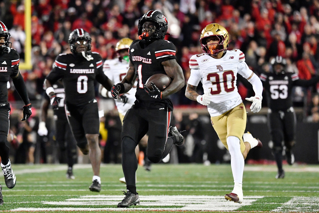 Louisville running back Isaac Brown (1) is pursued by Boston College defensive back TJ Green (30) during the first half of an NCAA college football game in Louisville, Ky., Saturday, Oct. 25, 2025. (AP Photo/Timothy D. Easley)