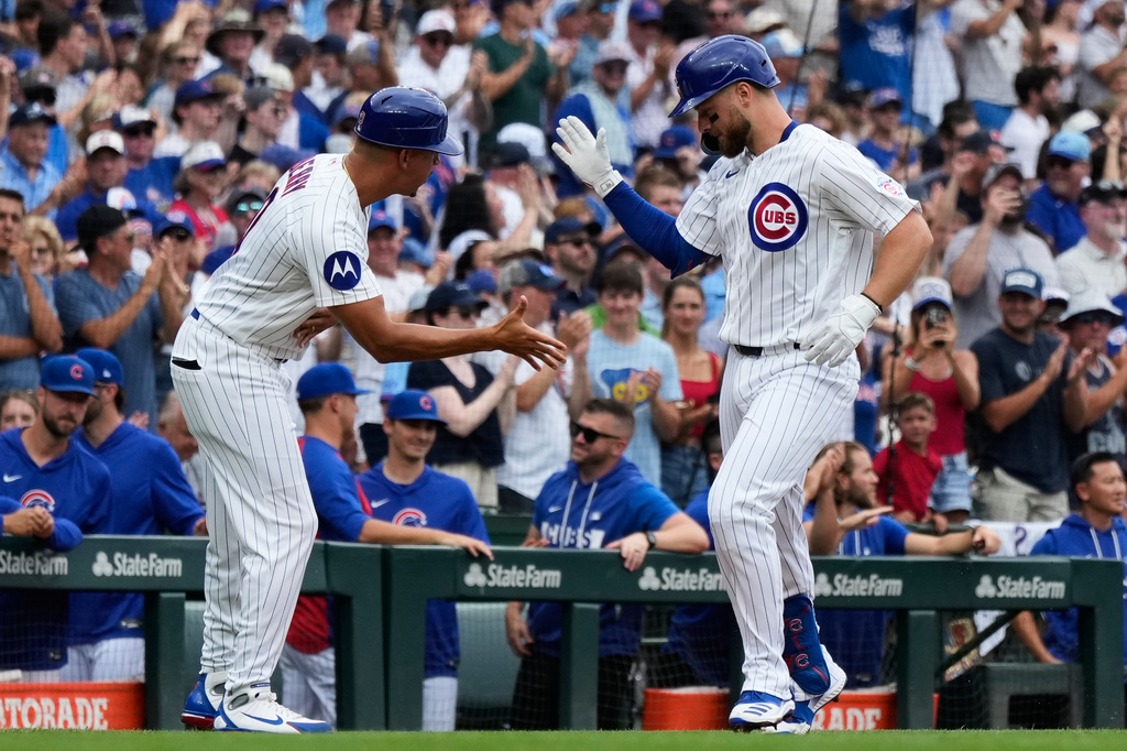 Chicago Cubs' Michael Busch, right, celebrates with third base coach Quintin Berry after hitting a solo home run during the first inning of a baseball game against the Minnesota Twins in Chicago, Saturday, July 18, 2026. (AP Photo/Nam Y. Huh)