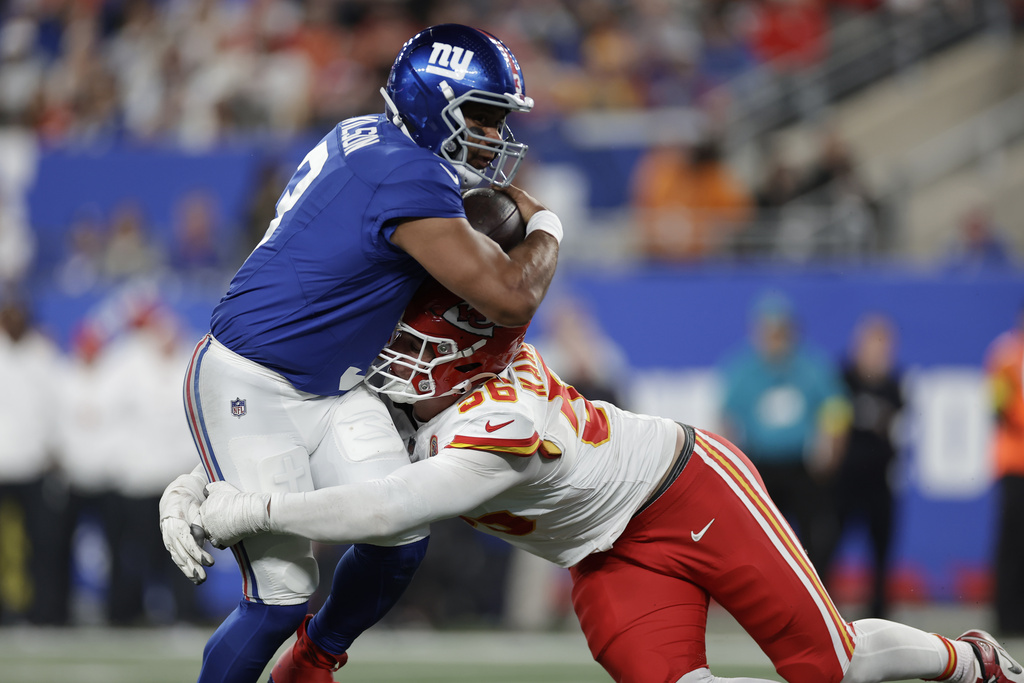 New York Giants quarterback Russell Wilson, left, runs with the ball as Kansas City Chiefs defensive end George Karlaftis (56) defends during the second half of an NFL football game Sunday, Sept. 21, 2025, in East Rutherford, N.J. (AP Photo/Adam Hunger)