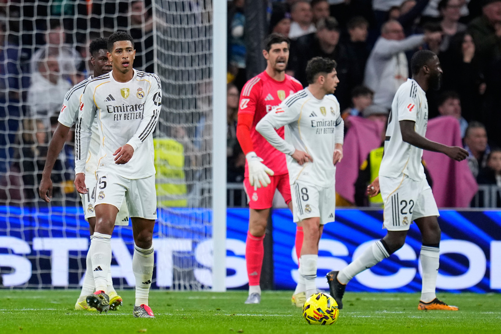 Real Madrid's Jude Bellingham, left, and teammates react after Celta's Williot Swedberg scored his side's second goal during the Spanish La Liga soccer match between Real Madrid and Celta Vigo in Madrid, Spain, Sunday, Dec. 7, 2025. (AP Photo/Manu Fernandez)