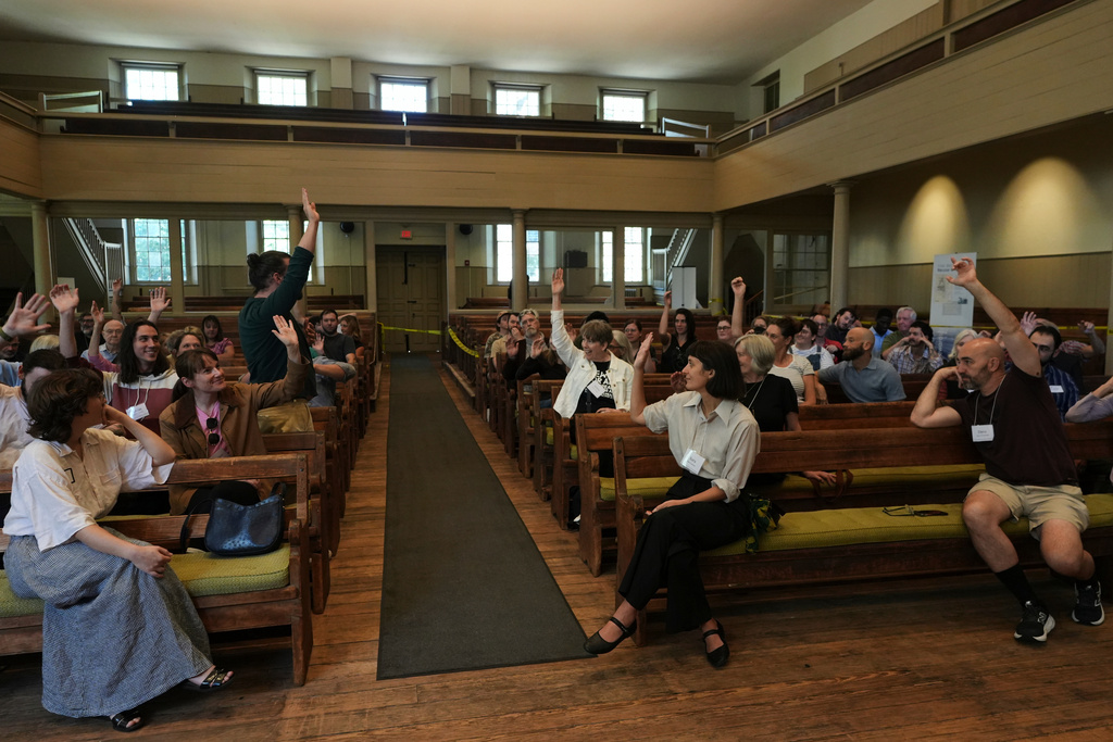 Quakers raise their hands after a worship service at the historic West Room of the Arch Street Meeting House in Philadelphia on Oct. 5, 2025. (AP Photo/Luis Andres Henao)