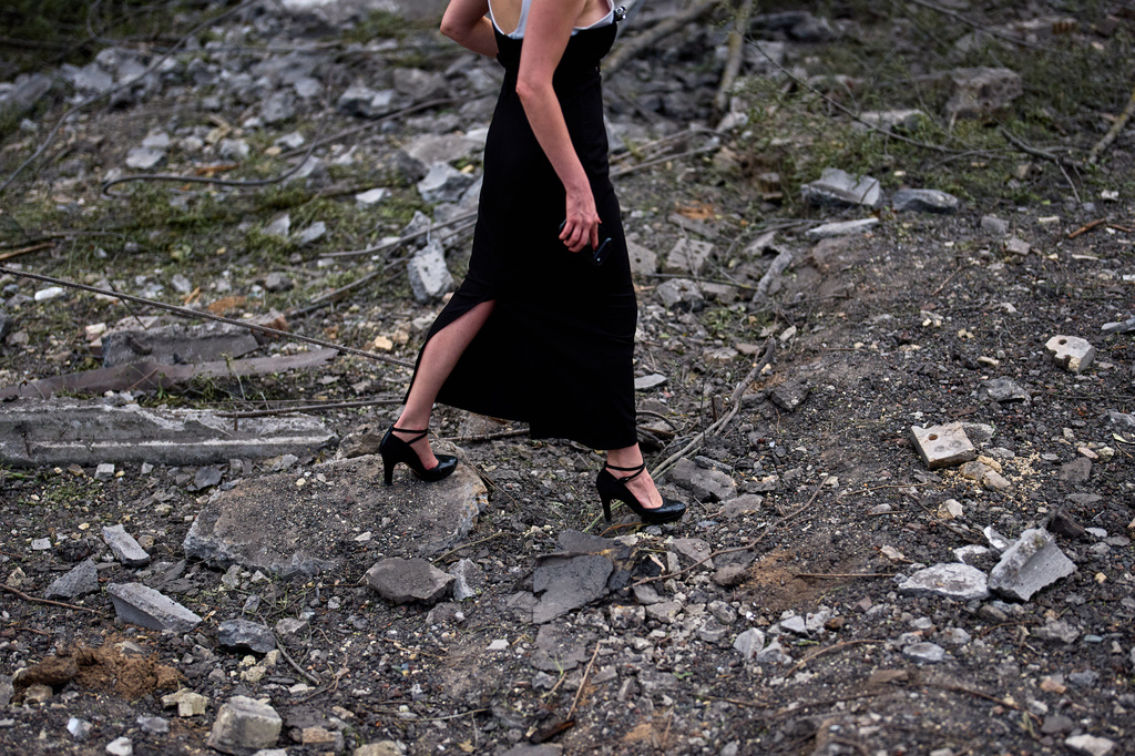 A woman walks across the debris in the aftermath of an overnight Russian missile and drone attack on Kyiv, Ukraine, Thursday, Aug. 20, 2026 (AP Photo/Francisco Seco)