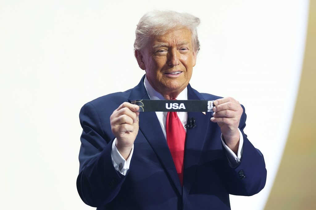 President Donald Trump smiles after drawing USA's name from a pot during the draw for the 2026 soccer World Cup at the Kennedy Center in Washington, Friday, Dec. 5, 2025. (Dan Mullan/Pool Photo via AP)