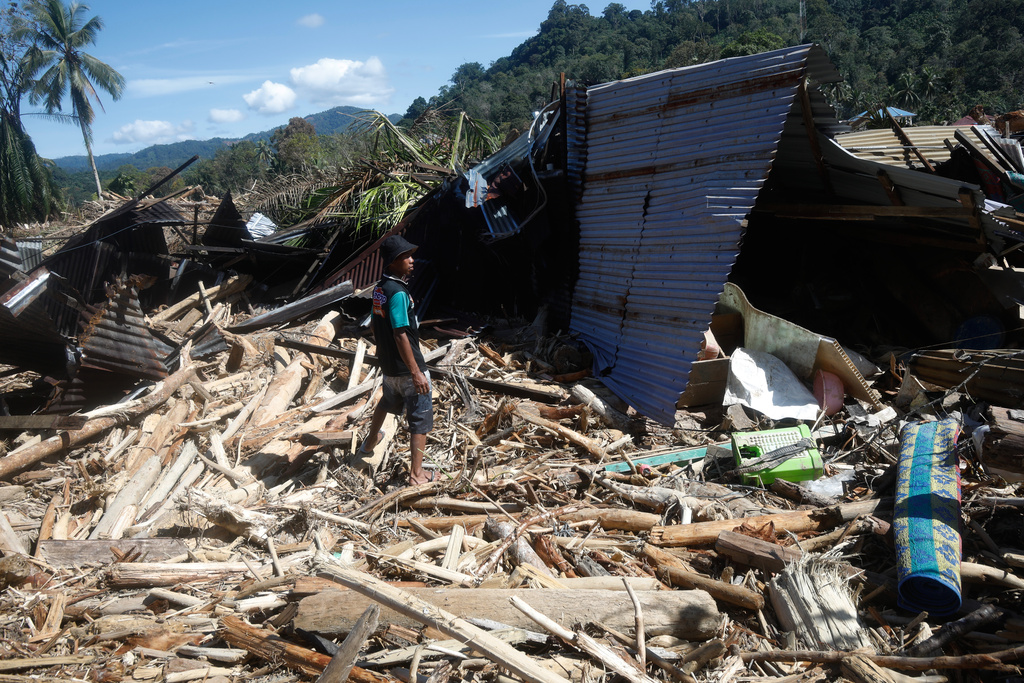 A flood survivor stands at the ruin of a house at a village affected by flash flood in Batang Toru, North Sumatra, Indonesia, Wednesday, Dec. 3, 2025. (AP Photo/Binsar Bakkara)