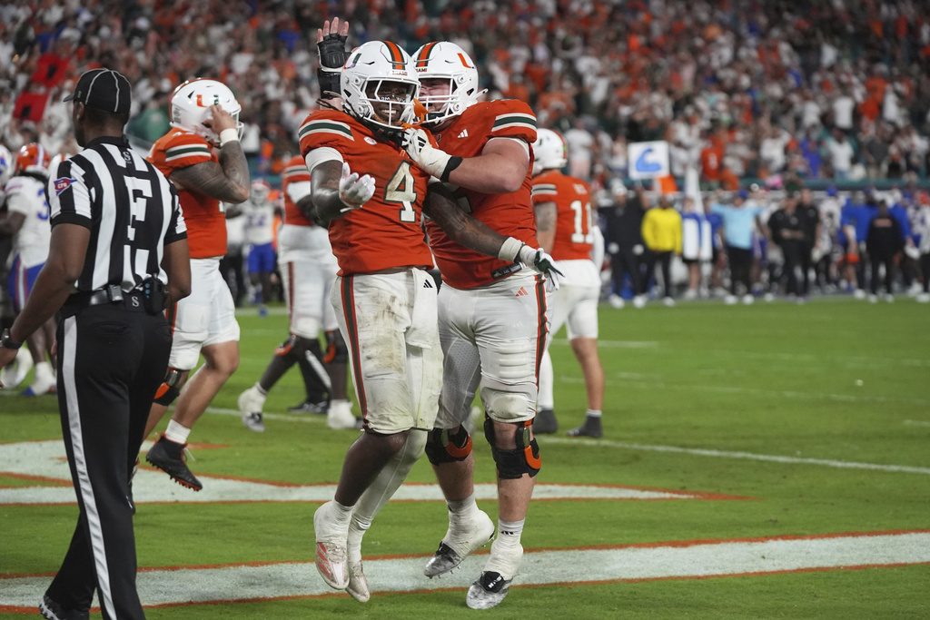 Miami running back Mark Fletcher Jr. (4) celebrates with offensive lineman James Brockermeyer, right, after scoring a touchdown during the second half of an NCAA college football game against Florida, Saturday, Sept. 20, 2025, in Miami Gardens, Fla. (AP Photo/Lynne Sladky)