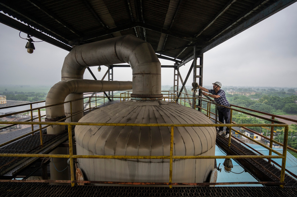FILE - A technician works on the top deck of a distillery at Bajaj Hindustan Sugar factory that produces ethanol, a type of biofuel, in Meerut, India, Aug. 23, 2023. (AP Photo/Altaf Qadri, File)