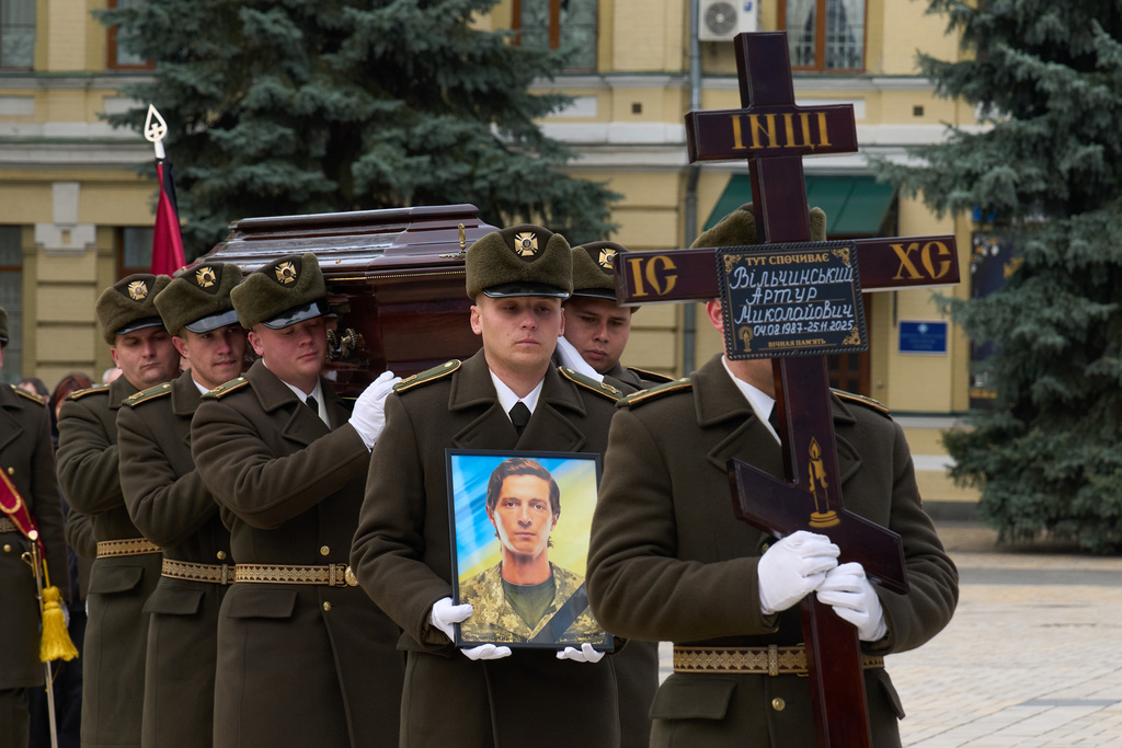 Servicemen carry coffins of their fellow soldiers Myroslava Kopcha and Artur Vilchynski, who were killed in Russia-Ukraine war, during a funeral ceremony at St. Michael Cathedral in Kyiv, Ukraine, Friday, Nov. 28, 2025. (AP Photo/Efrem Lukatsky)
