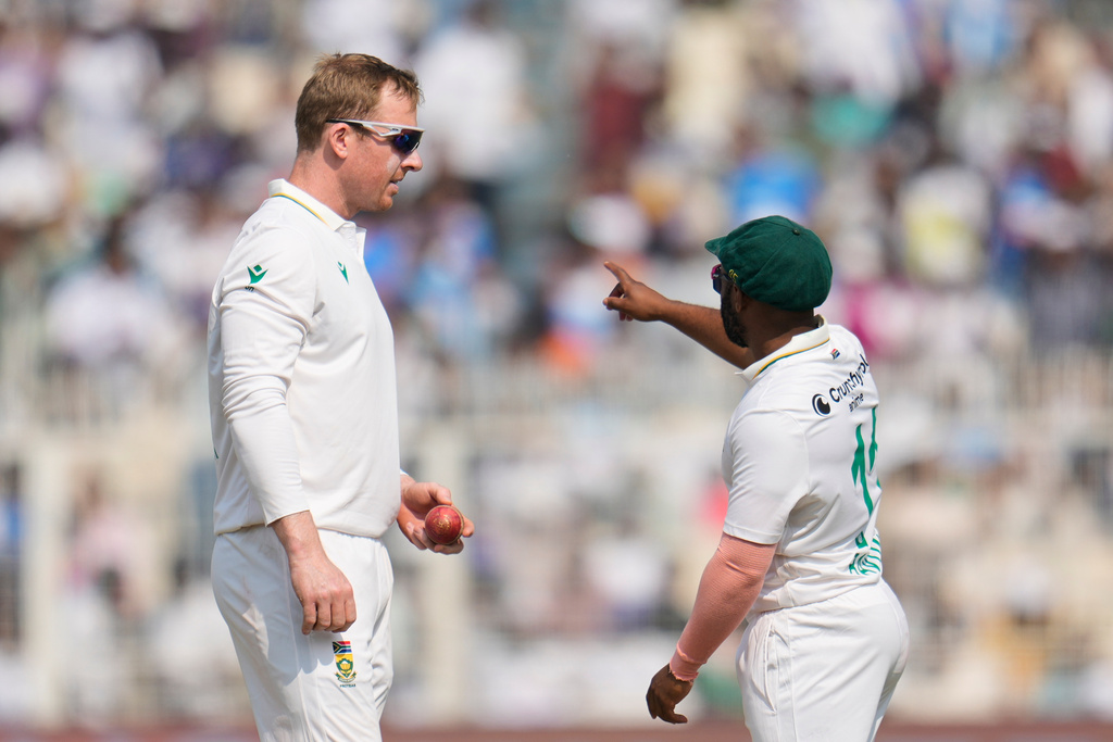 South Africa's Simon Harmer, left, listens to captain Temba Bavuma before bowling his next delivery on the second day of the first cricket test match between India and South Africa in Kolkata, India, Saturday, Nov. 15, 2025. (AP Photo/Aijaz Rahi)