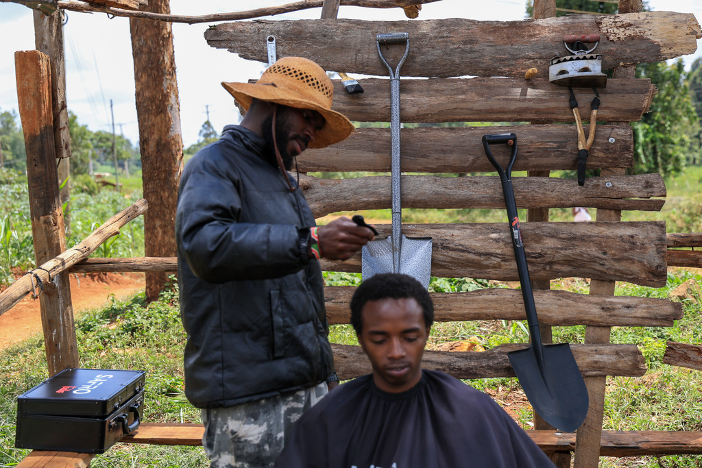 Safari Martins, a barber whose creative techniques have gained him an online following, shaves Ian Njenga in Kiambu, Kenya, Wednesday, Nov. 26, 2025. (AP Photo/Andrew Kasuku)