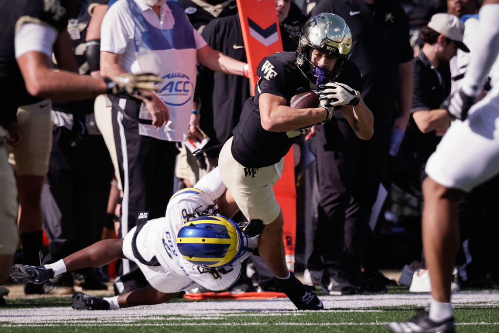 Wake Forest's Carlos Hernandez (8) is tackled by Delaware's Kshawn Cox Jr. (6) during the first half of an NCAA football game, Saturday, Nov. 22, 2025, in Winston-Salem, N.C. (Allison Lee Isley/The Winston-Salem Journal via AP)