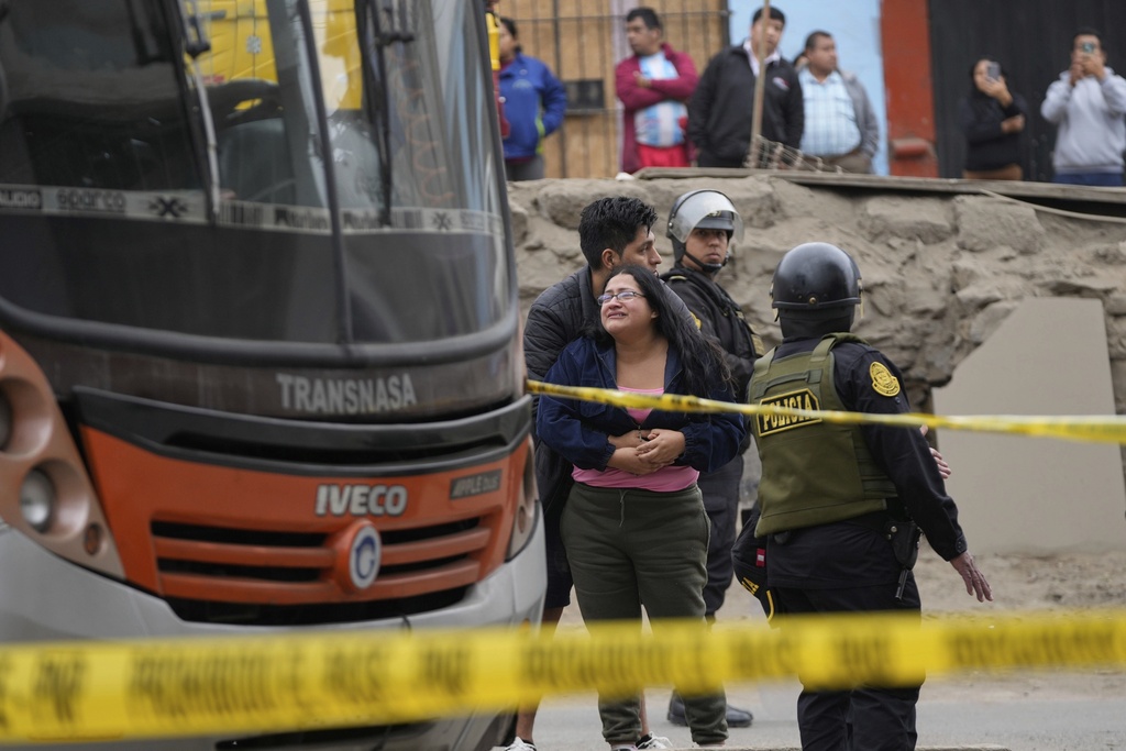 Relatives of bus driver Arturo Ramon cry next the bus where he was killed in the San Juan de Miraflores neighborhood of Lima, Peru, Monday, Sept. 8, 2025. (AP Photo/Martin Mejia)