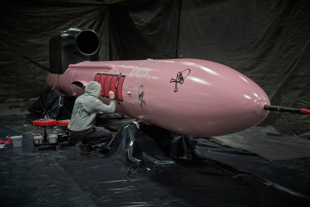 A painter writes "Dana 1" referring to Czech nuclear physicist Dana Drabova on the side of a Flamingo cruise missile, which was paid by a crowdfunding campaign of a Czech organization, Weapons to Ukraine, at the Fire Point factory at an undisclosed location in Ukraine, Sunday, Nov. 16, 2025. (AP Photo/Efrem Lukatsky)