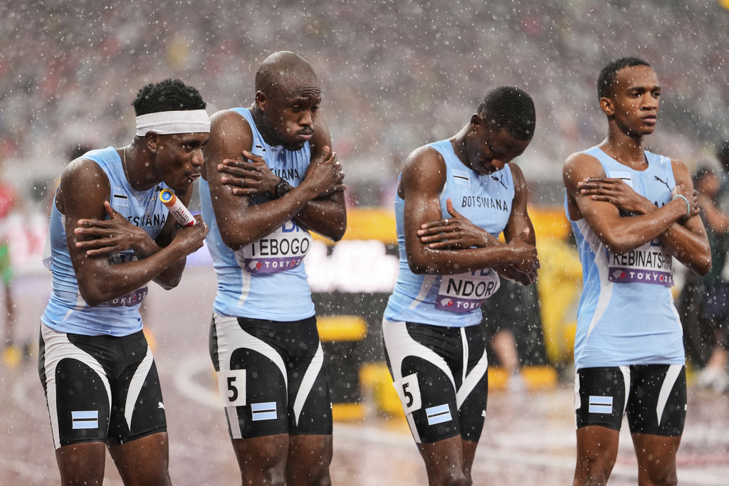 Team Botswana react to the cold rain before the start of the men's 4 X 400 meters relay at the World Athletics Championships in Tokyo, Sunday, Sept. 21, 2025. (AP Photo/Eugene Hoshiko)