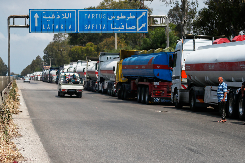 Iraqi trucks loaded with oil wait to drive toward the Baniyas oil refinery along a highway in Tartus Governorate, western Syria, Friday, May 1, 2026. (AP Photo/Omar Sanadiki)