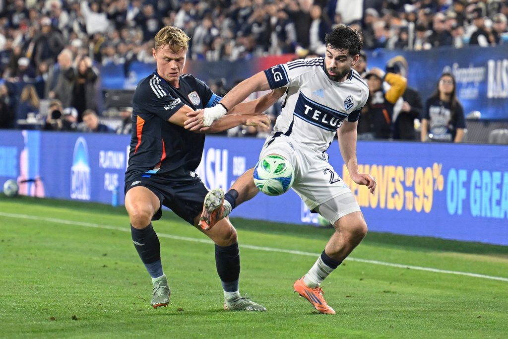 San Diego FC defender Jeppe Tverskov (6) fights for the ball with Vancouver Whitecaps forward Brian White (24) during the first half of an MLS Western Conference final soccer match Saturday, Nov. 29, 2025, in San Diego. (AP Photo/Denis Poroy)