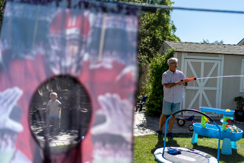 Christy Morrill, who lost decades of memories to autoimmune encephalitis, plays in his backyard with his grandson, Colter, 1, Tuesday, Aug. 19, 2025, in San Carlos, Calif. (AP Photo/David Goldman)