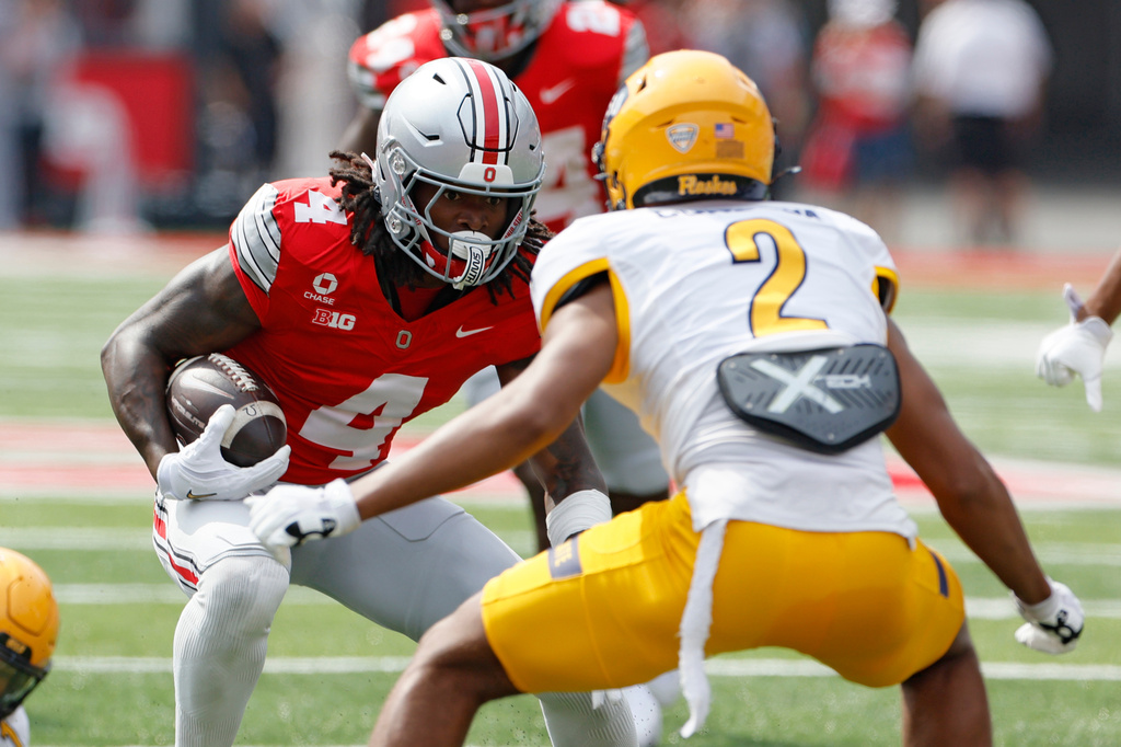 Ohio State wide receiver Jeremiah Smith, left, tries to get past Kent State defensive back Joel Cordoba after a catch during the first half of an NCAA college football game, Saturday, Sept. 19, 2026, in Columbus, Ohio. (AP Photo/Jay LaPrete)