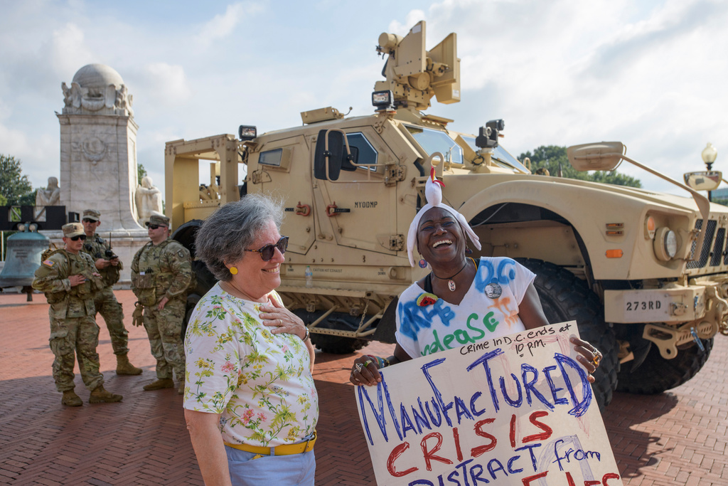 Nadine Seiler, right, talks, near National Guard solders from South Carolina, outside Union Station in Washington, Wednesday, Aug. 20, 2025. (AP Photo/Rod Lamkey, Jr.)