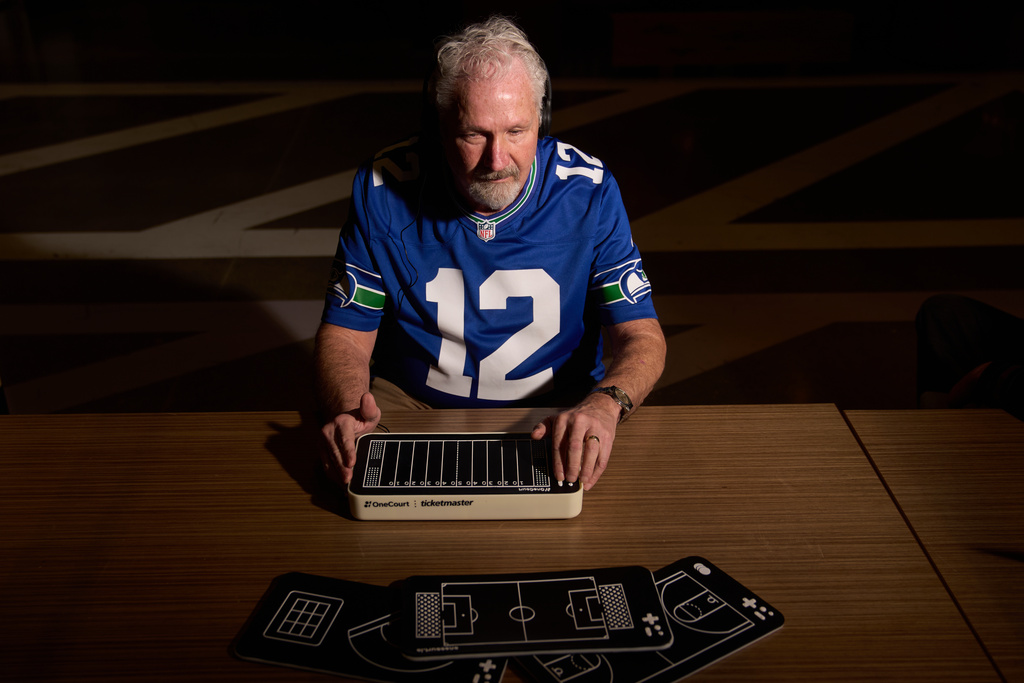 Clark Roberts, a blind Seattle Seahawks fan, uses a OneCourt tablet, a tactile device that translates gameplay into trackable vibrations along with real-time audio, at the T-Mobile Innovation Hub Tuesday, Jan. 27, 2026, in Bellevue, Wash. (AP Photo/Lindsey Wasson)