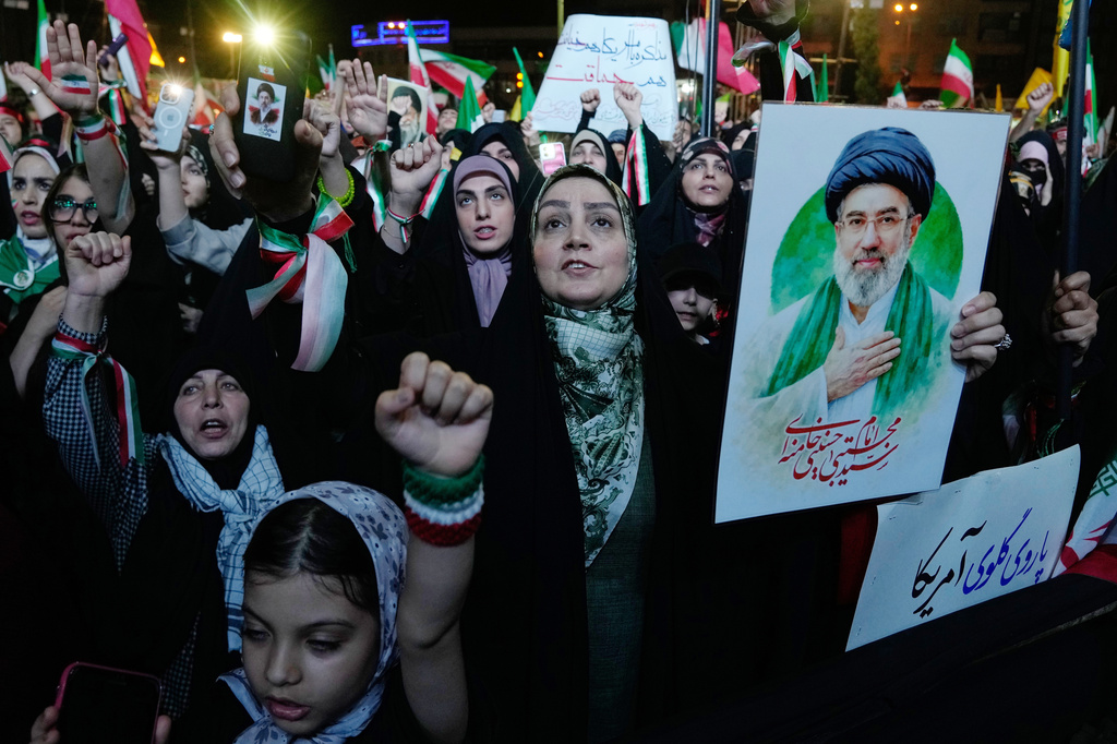 Pro-government demonstrators chant slogans as one of them holds a poster of the Iranian Supreme Leader Ayatollah Mojtaba Khamenei during their gathering at Enqelab-e-Eslami, or Islamic Revolution, square in Tehran, Iran, Monday, May 4, 2026. (AP Photo/Vahid Salemi)