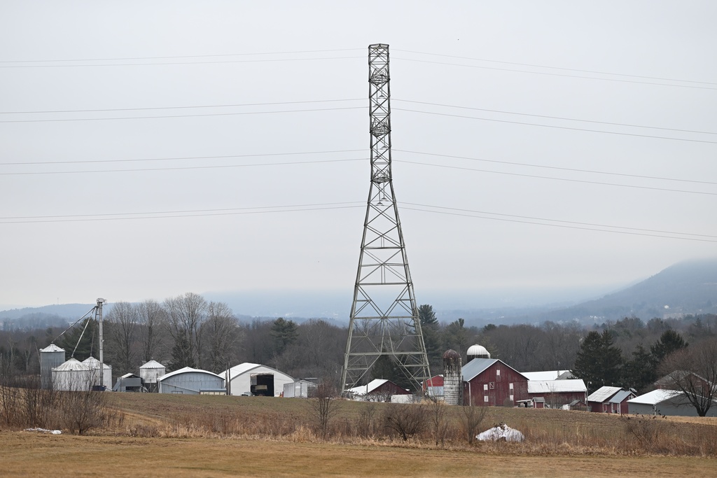 A 235-kilovolt power line towers over farm buildings near where the local power utility plans to build a 500-kilovolt power line on towers as tall as 240 feet, March 4, 2026, in Sugarloaf, Pa. (AP Photo/Marc Levy)