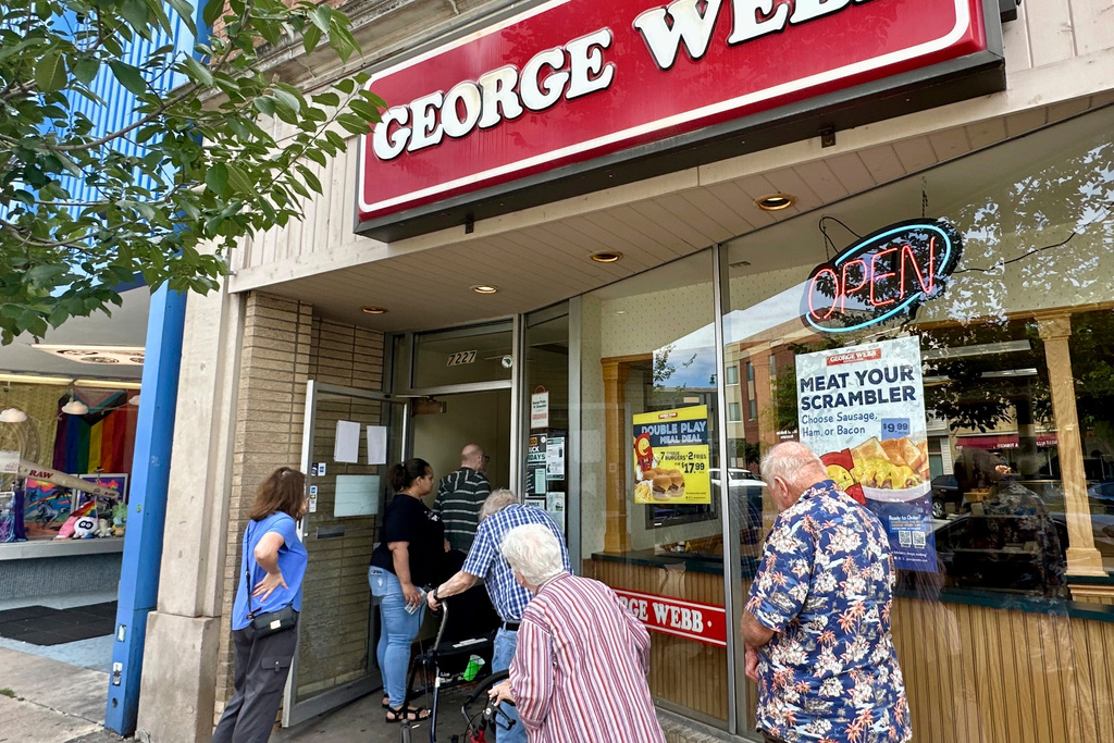 Fans line up outside a George Webb restaurant in Milwaukee, Wednesday, Aug. 20, 2025, to capitalize on a giveaway by the local fast-food chain, which gives out free hamburgers whenever the Milwaukee Brewers win at least 12 straight games. (AP Photo/Steve Megargee)