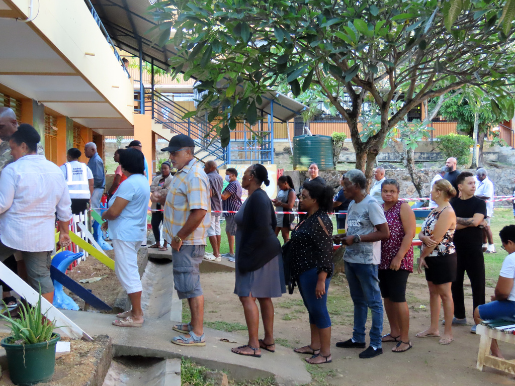 People line up to cast their votes in a runoff presidential election at Mont Fleuri Secondary School, Mont Fleuri, Mahe, Seychelles, Saturday, Oct. 11, 2025. (AP Photo/Emilie Chetty)