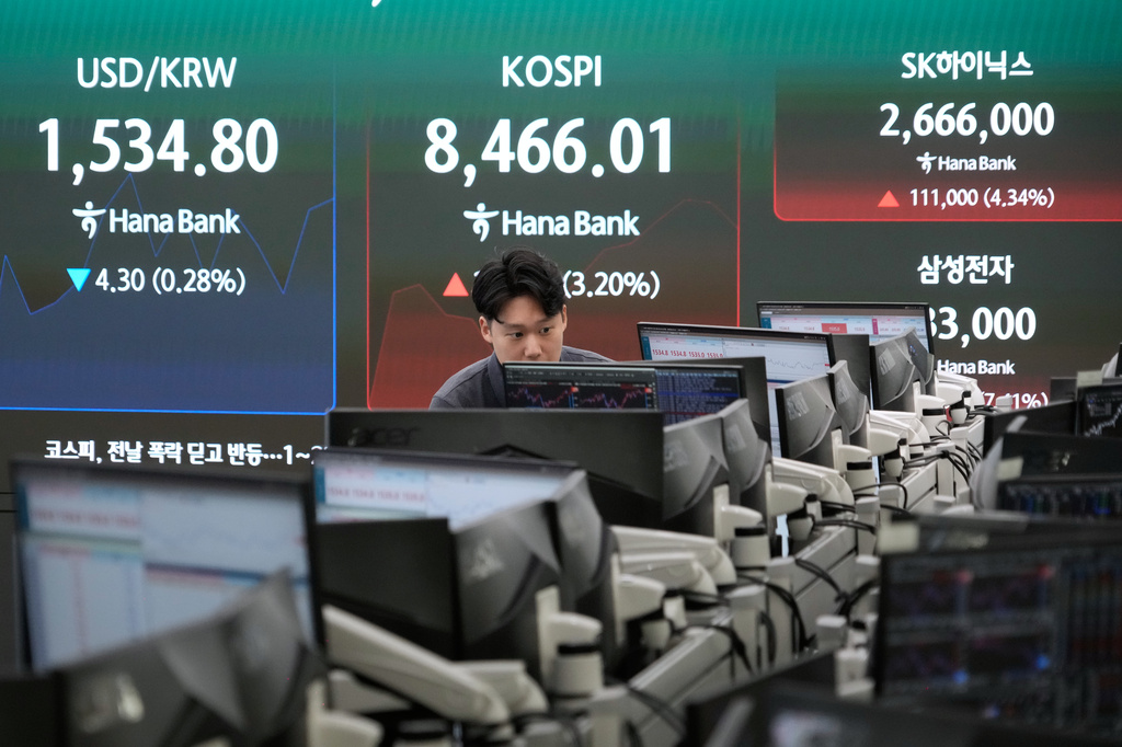 A currency trader watches monitors near a screen showing the Korea Composite Stock Price Index (KOSPI) and the foreign exchange rate between U.S. dollar and South Korean won at the foreign exchange dealing room of the Hana Bank headquarters in Seoul, South Korea, Wednesday, June 24, 2026. (AP Photo/Ahn Young-joon)