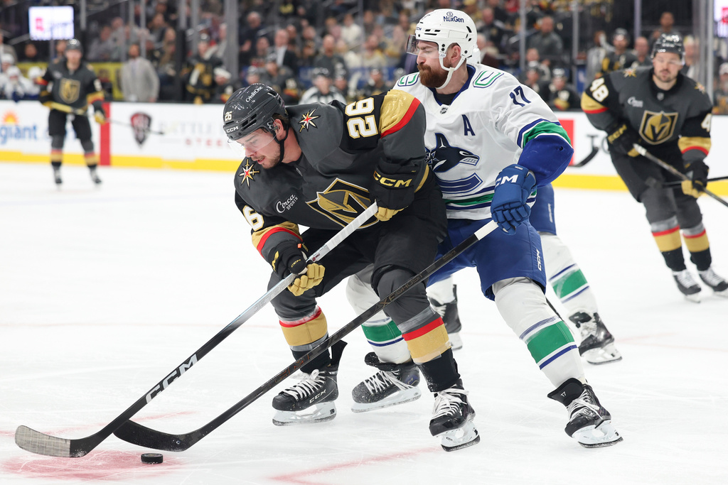 Vegas Golden Knights right wing Alexander Holtz (26) skates against Vancouver Canucks defenseman Filip Hronek (17) during the second period of an NHL hockey game Wednesday, Feb. 4, 2026, in Las Vegas. (AP Photo/Ian Maule)