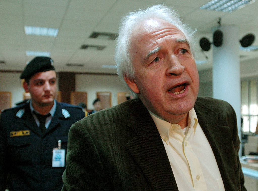FILE- Convicted leader of the armed group November 17, Alexandros Giotopoulos speaks to reporters, at a special court in a top-security Athens jail, on Dec. 2, 2005. (AP Photo/Thanassis Stavrakis, File)