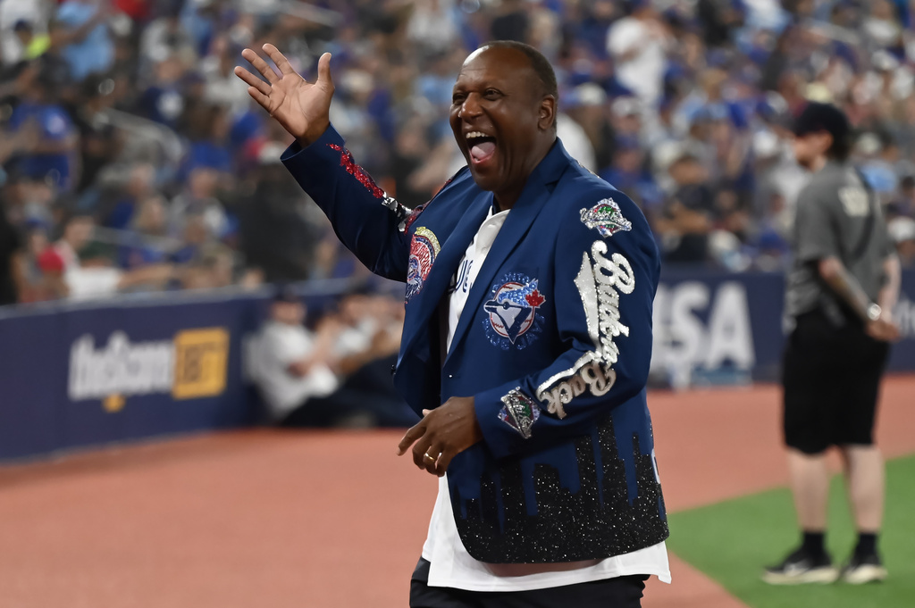Toronto Blue Jays alumni Joe Carter waves to the crowd while taking part in the 1992-1993 commemoration and statue unveiling prior to the Jays taking on the Chicago White Sox in a baseball game in Toronto, Saturday, July 18, 2026. (Jon Blacker/The Canadian Press via AP)