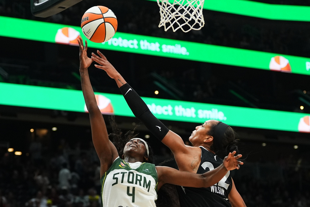 Las Vegas Aces center A'ja Wilson knocks the ball away from Seattle Storm guard Flau'jae Johnson (4) at the basket during the first half of a WNBA basketball game, Thursday, Sept. 17, 2026, in Seattle. (AP Photo/Lindsey Wasson)