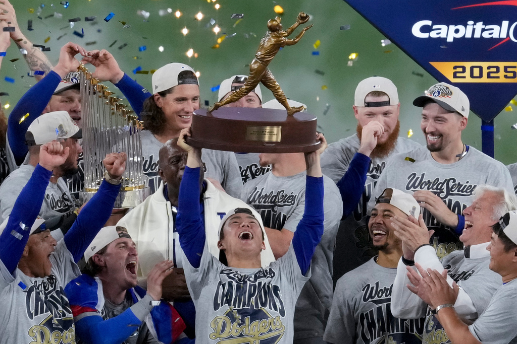 FILE - Los Angeles Dodgers World Series MVP Yoshinobu Yamamoto holds his trophy as teammates celebrate their win in Game 7 of baseball's World Series against the Toronto Blue Jays, Sunday, Nov. 2, 2025, in Toronto. (AP Photo/Ashley Landis, File)