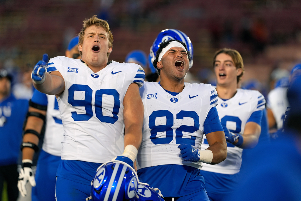 BYU defensive end Hunter Clegg (90) and tight end Noah Moeaki (82) celebrate with fans after a win over Iowa State in an NCAA college football game, Saturday, Oct. 25, 2025, in Ames, Iowa. (AP Photo/Matthew Putney)