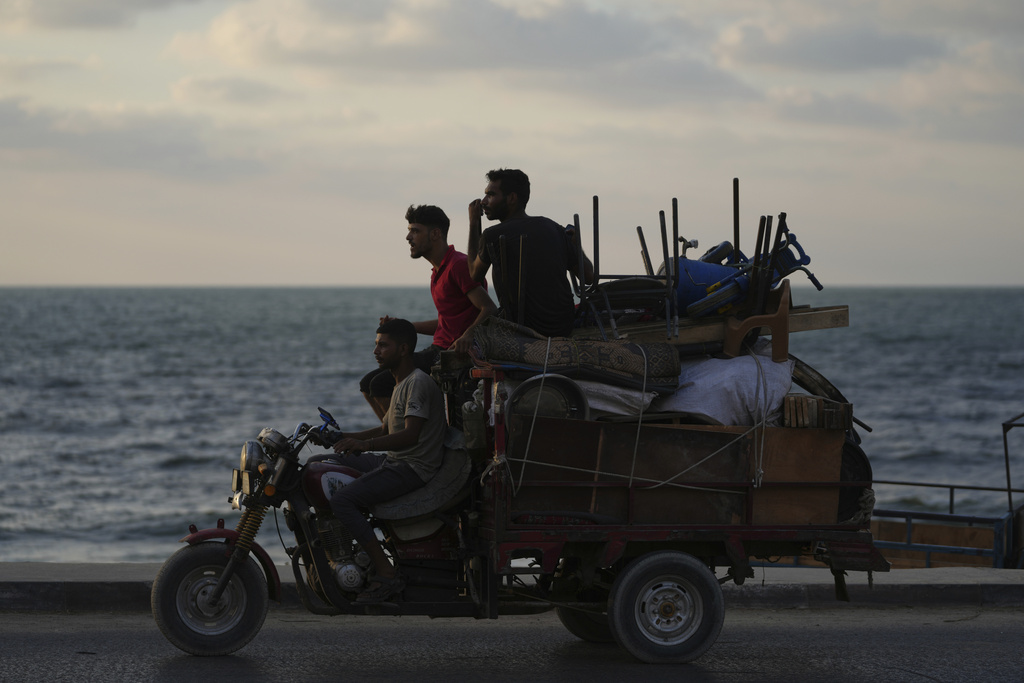 Displaced Palestinians fleeing northern Gaza carry their belongings along the coastal road toward southern Gaza, Saturday, Sept. 6, 2025. (AP Photo/Jehad Alshrafi)