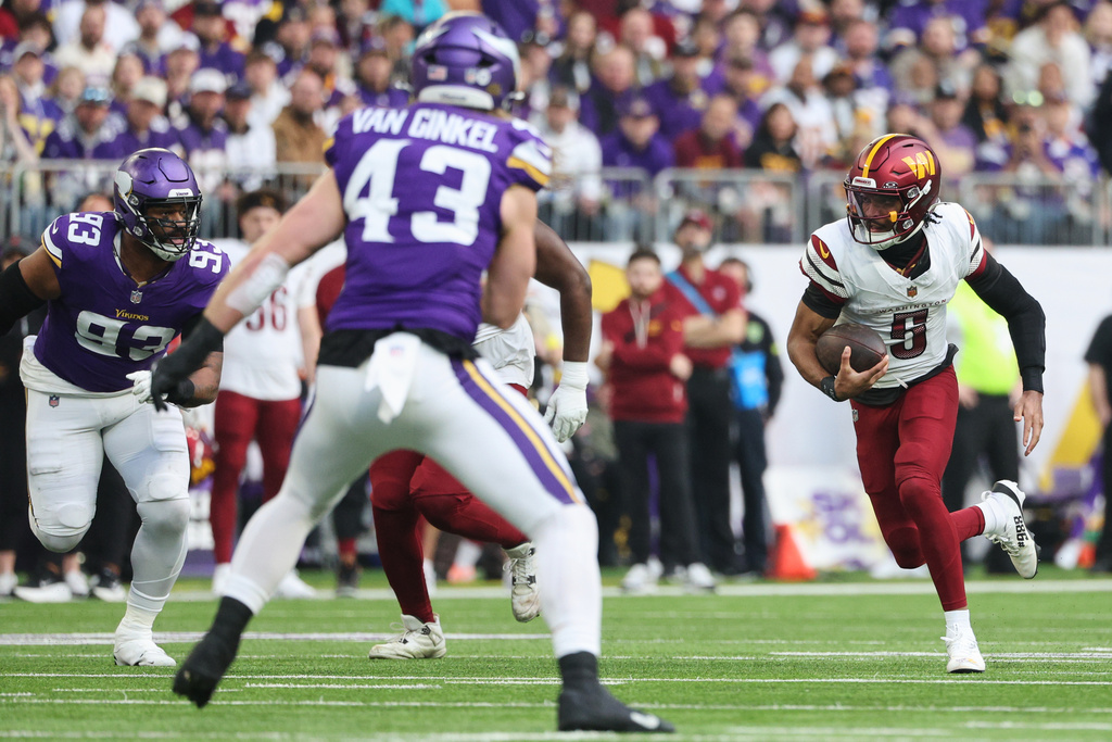 Washington Commanders quarterback Jayden Daniels (5) runs with the ball during the first half of an NFL football game against the Minnesota Vikings, Sunday, Dec. 7, 2025, in Minneapolis. (AP Photo/Matt Krohn)