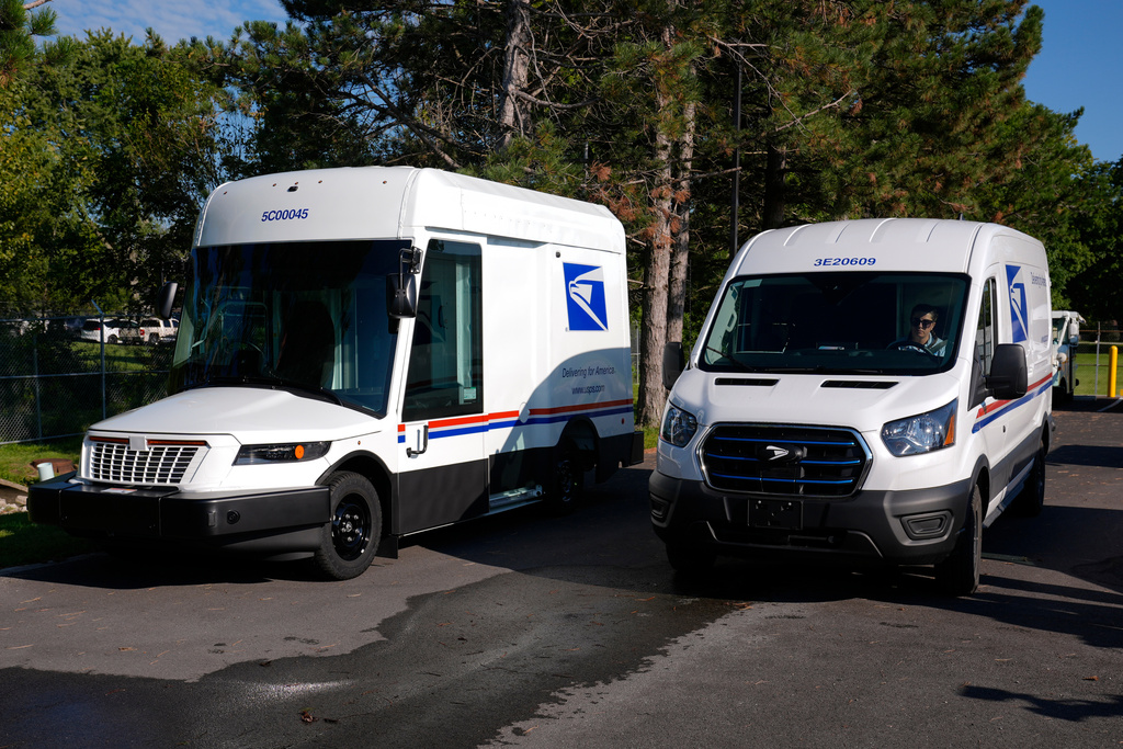 FILE - The U.S. Postal Service's next-generation delivery vehicle, left, is displayed as one new battery electric delivery trucks leaves the Kokomo Sorting and Delivery Center in Kokomo, Ind., Aug. 29, 2024. (AP Photo/Michael Conroy, File)