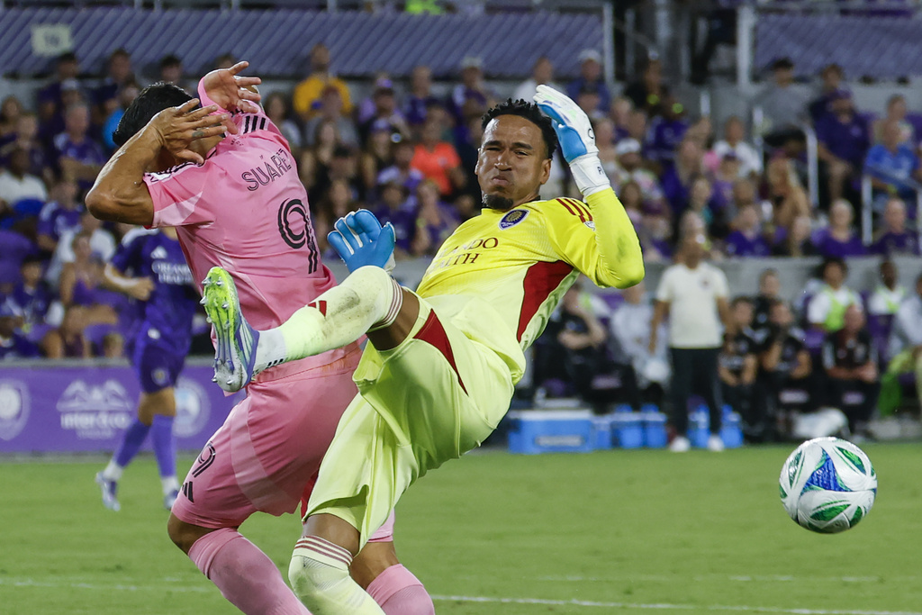 Orlando City goalkeeper Pedro Gallese, right, and Inter Miami forward Luis Suárez, left, go for the ball during the first half of an MLS soccer match, Sunday, Aug. 10, 2025, in Orlando, Fla. (AP Photo/Kevin Kolczynski)