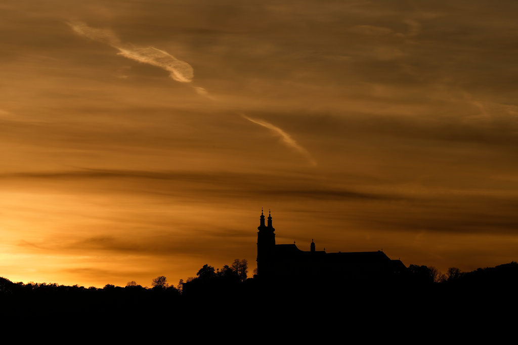 The suns sets behind the catholic monastery church of Banz in Bad Staffelstein, Germany, Saturday, May 2, 2026. (AP Photo/Matthias Schrader)