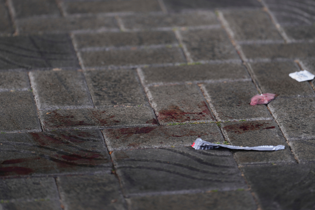 Blood stains mark the pavement the day after a shooting at Seattle Center during the Bite of Seattle food festival, Monday, July 27, 2026. (AP Photo/Lindsey Wasson)