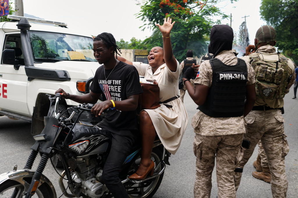 A woman reacts to tear gas fired by police to disperse protesters demanding the reopening of the General Hospital in Port-au-Prince, Haiti, Wednesday, July 1, 2026. (AP Photo/Odelyn Joseph)