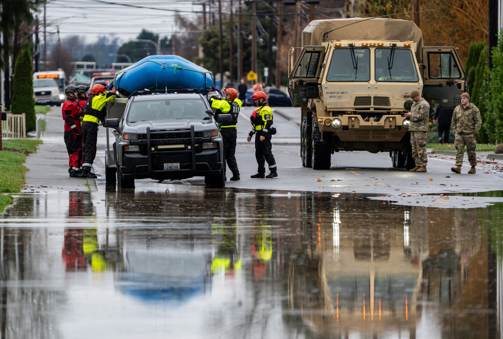 Emergency crews, including National Guard soldiers, wort in a neighborhood flooded by the Skagit River on Friday, Dec. 12, 2025, in Burlington, Wash. (AP Photo/Stephen Brashear)