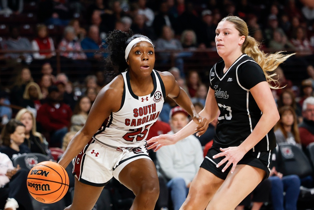 South Carolina guard Raven Johnson, left, drives against Providence forward Ashley Dinges during the first half of an NCAA college basketball game in Columbia, S.C., Sunday, Dec. 28, 2025. (AP Photo/Nell Redmond)