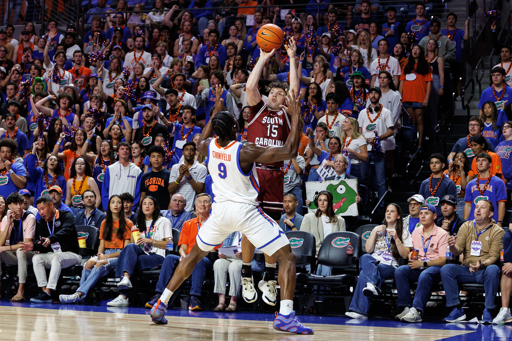South Carolina guard Eli Ellis (15) shoots over Florida center Rueben Chinyelu (9) during the first half of an NCAA college basketball game, Tuesday, Feb. 17, 2026, in Gainesville, Fla. (AP Photo/Chris Watkins)