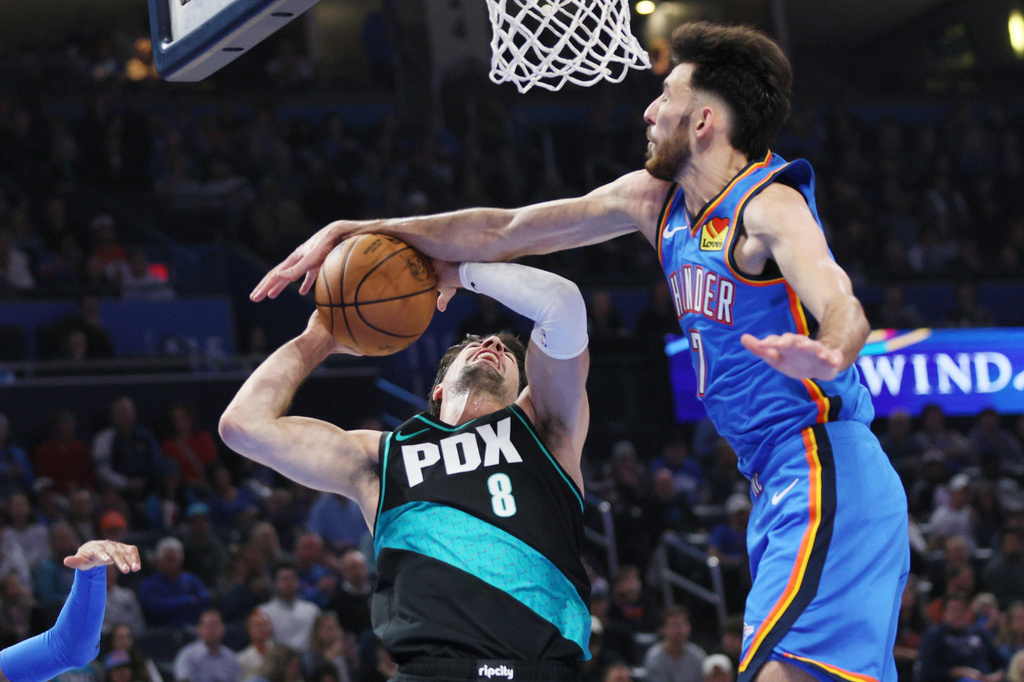 Oklahoma City Thunder center Chet Holmgren, right, knocks the ball away from Portland Trail Blazers forward Deni Avdija (8) during the first half of an NBA basketball game, Sunday, Nov. 23, 2025, in Oklahoma City. (AP Photo/Nate Billings)
