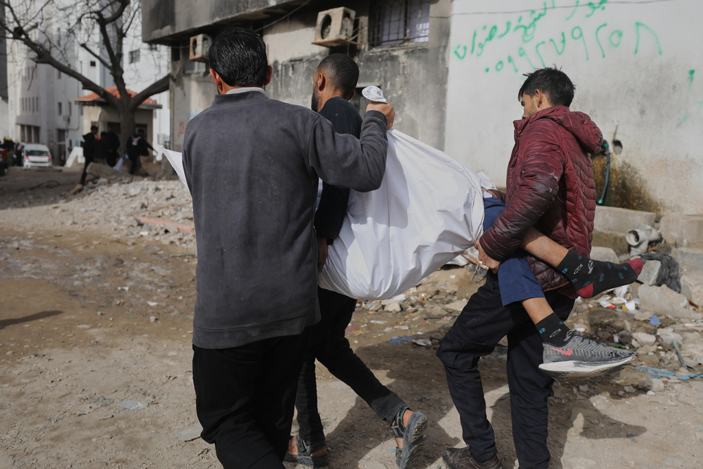 Palestinians carry the body of Mohammad Zawara, 15, who was killed in an Israeli strike, according to health officials, as they arrive at Shifa Hospital, Gaza City, Saturday, Jan. 24, 2026. (AP Photo/Yousef Al Zanoun)